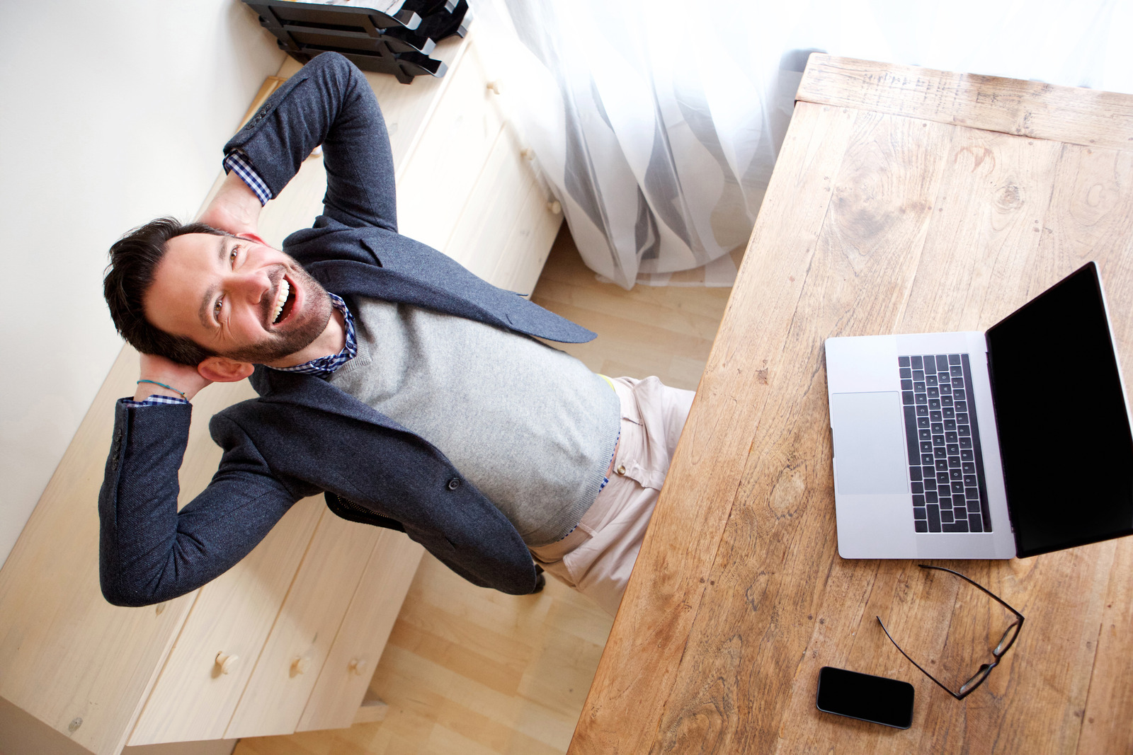 happy businessman relaxing in office with laptop