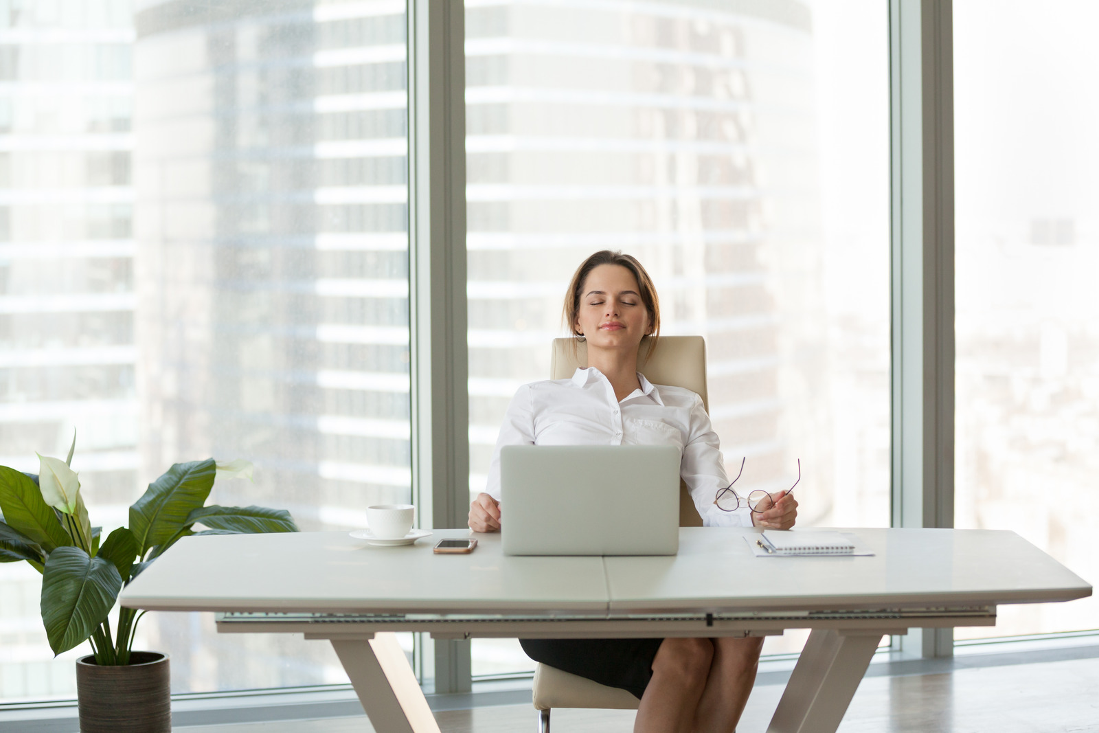 Young businesswoman relaxing leaning on comfortable ergonomic chair in office